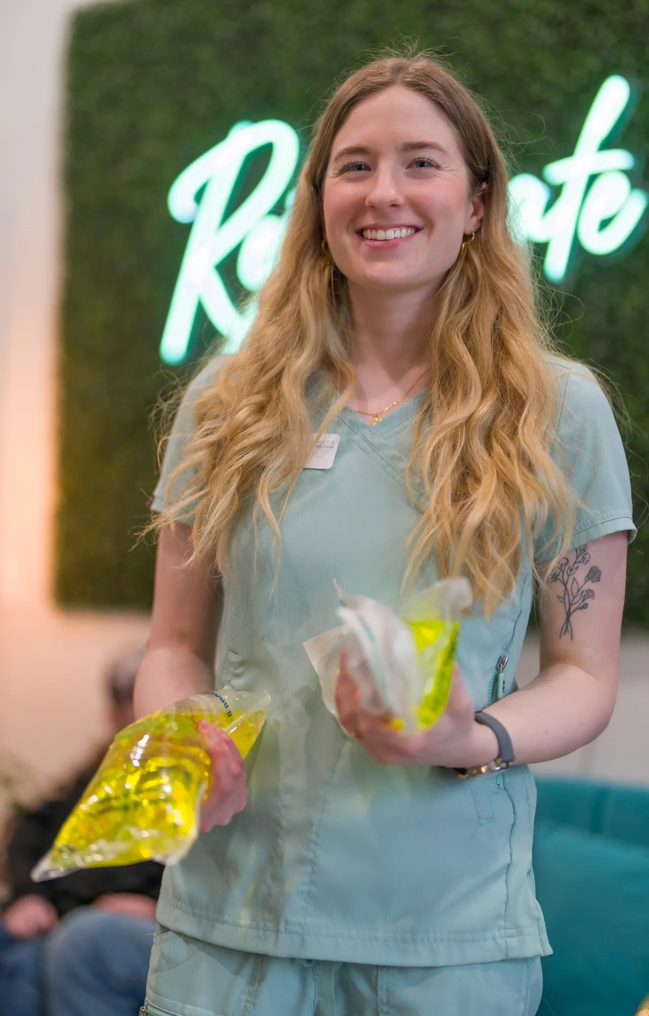 a woman holding two bags of yellow liquid - rs=w_1280,h_2004